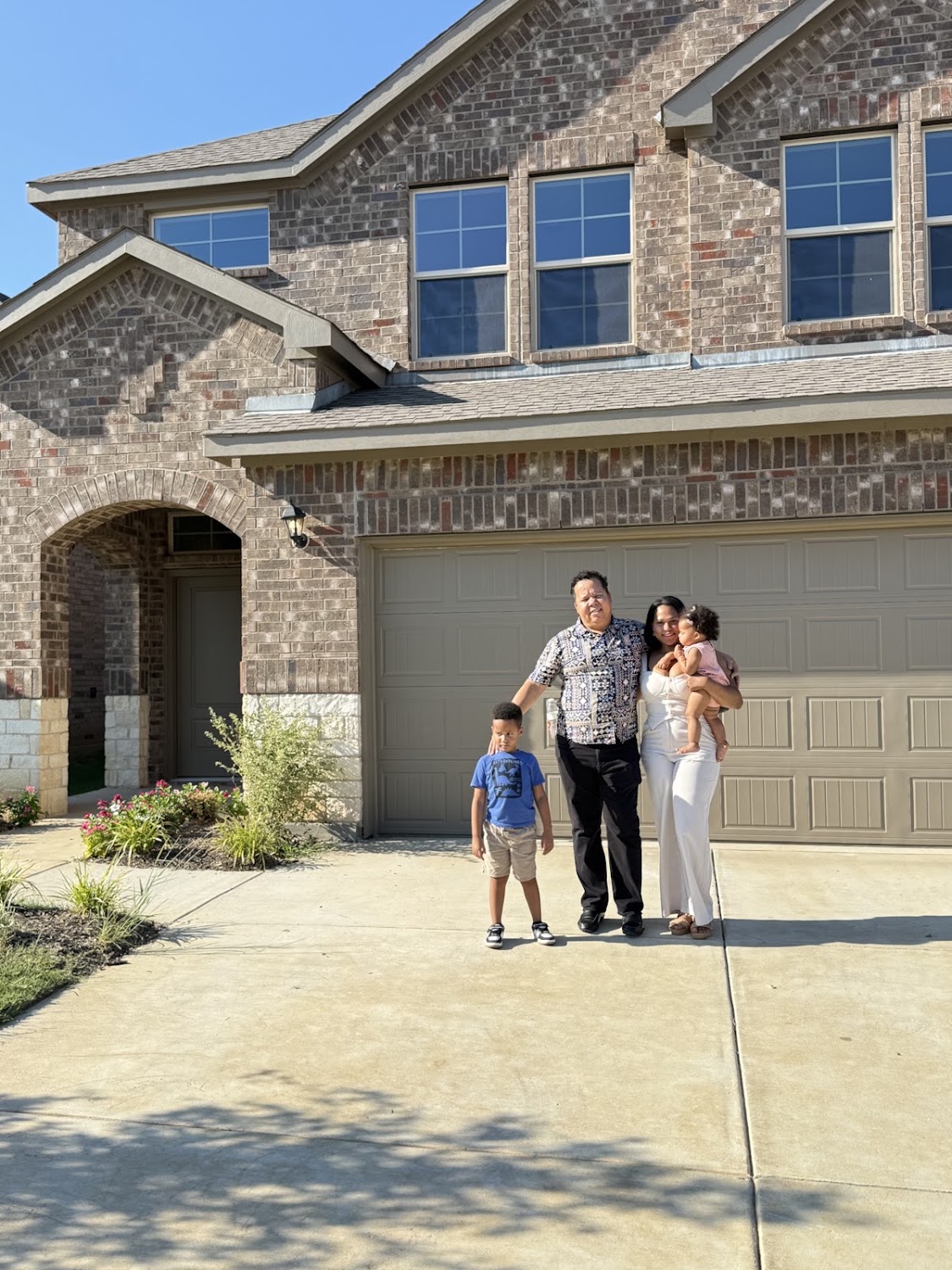 Andrea Becker with a family in front of their newly purchased Frisco home